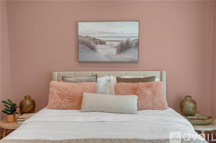 A bedroom with a large bed and a painting above it.