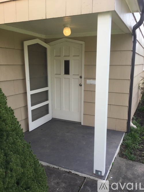 A white door with a glass panel is on the left and a white pillar on the right.