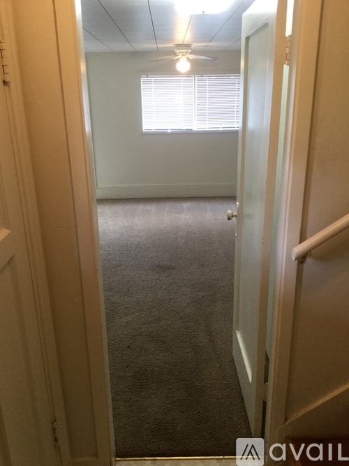 A hallway with a carpeted floor and a door on the right.