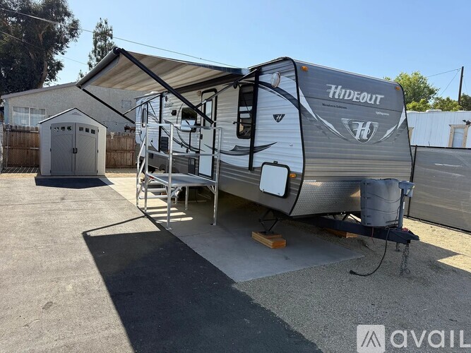 A Hideout RV is parked in a driveway.
