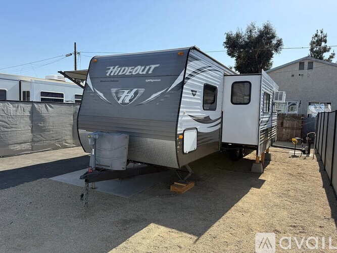 A Hideout camper is parked in a lot.