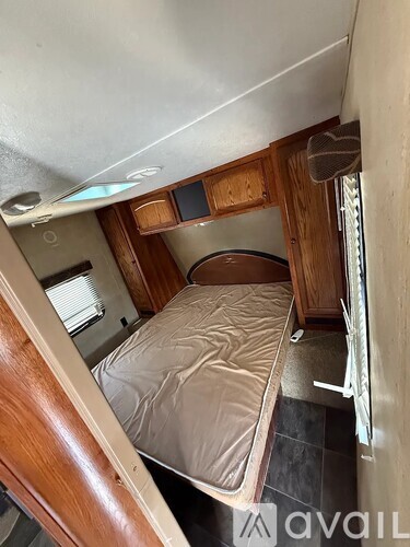 A small bed in a narrow space with a wooden headboard and footboard.