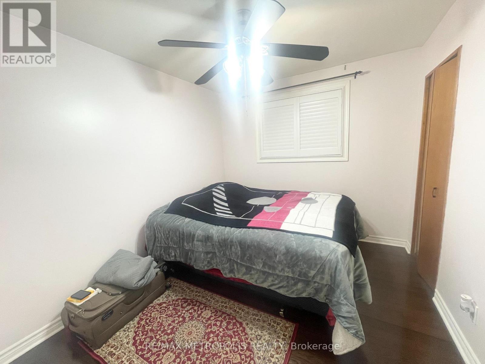 A bedroom with a bed, pillow, and a ceiling fan.