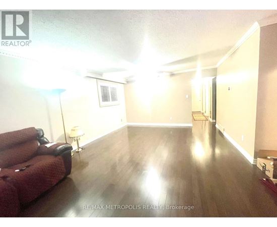 A living room with a red couch and wooden floors.
