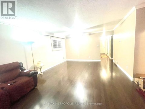 A living room with a red couch and wooden floors.