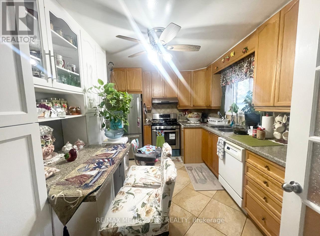 A kitchen with wooden cabinets and a ceiling fan.