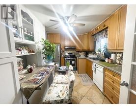 A kitchen with wooden cabinets and a ceiling fan.