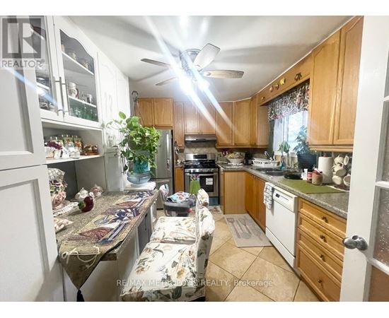 A kitchen with wooden cabinets and a ceiling fan.