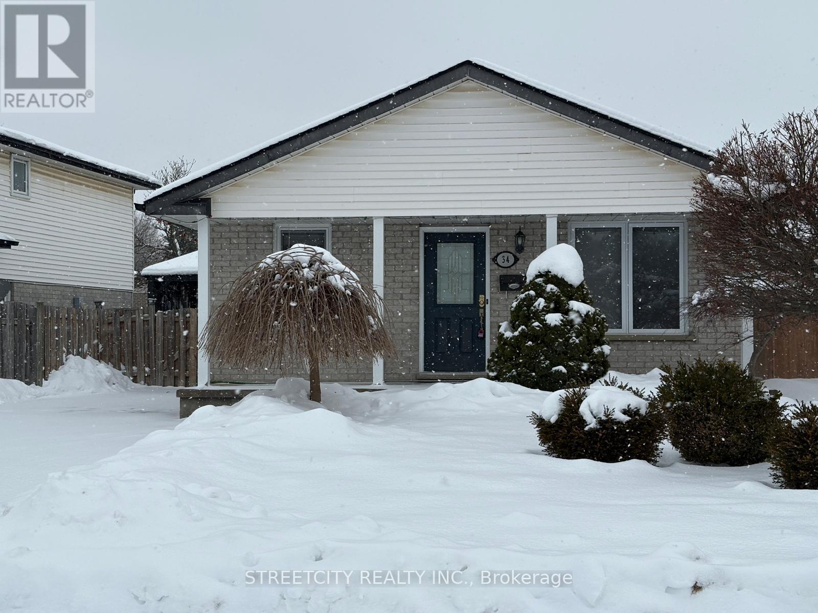 A house with a snow-covered front yard.