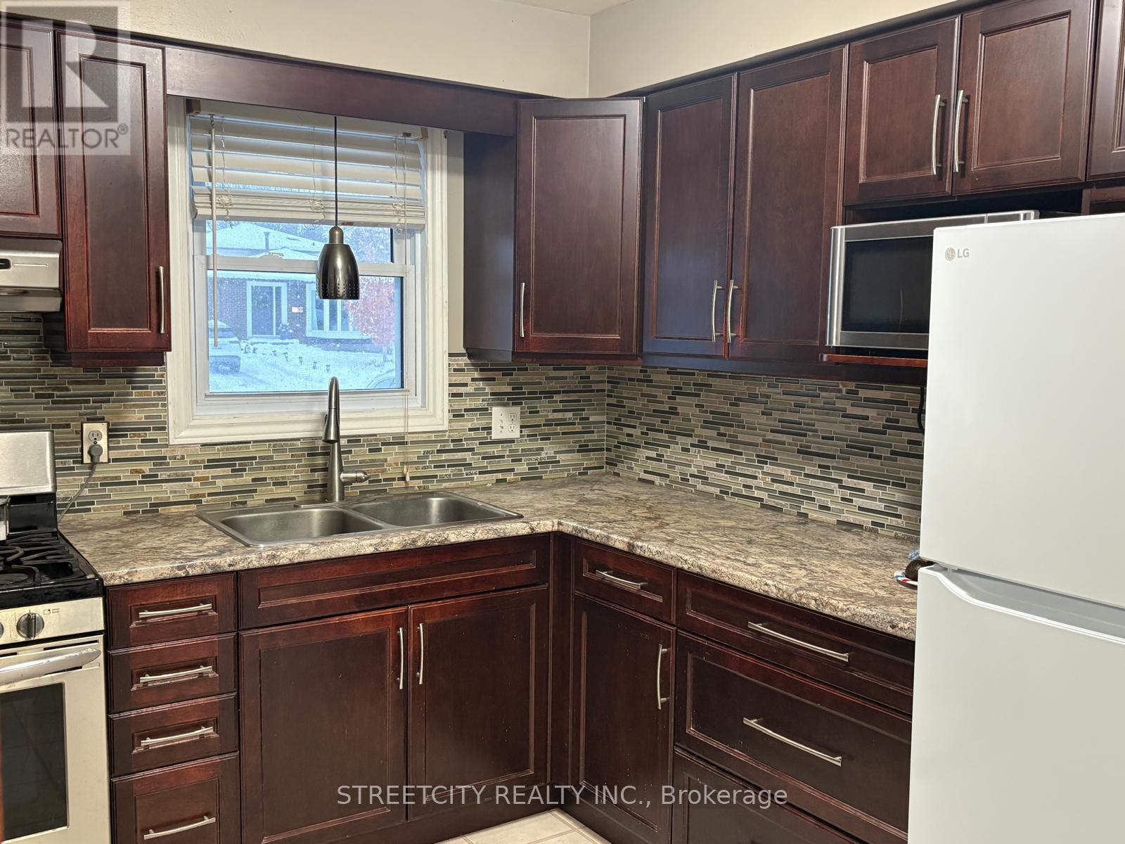 A kitchen with brown cabinets and a white fridge.