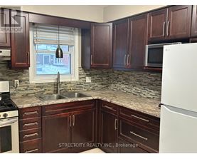 A kitchen with brown cabinets and a white fridge.