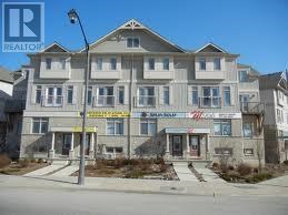 A large, two-story building with a realtor sign in the window.