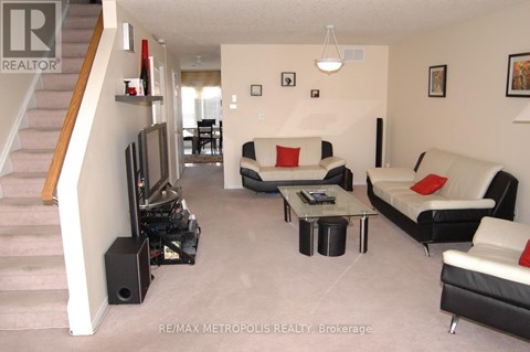 A living room with a couch, chair, and television.