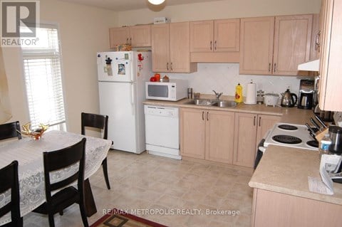 A kitchen with a table and chairs in front of it.