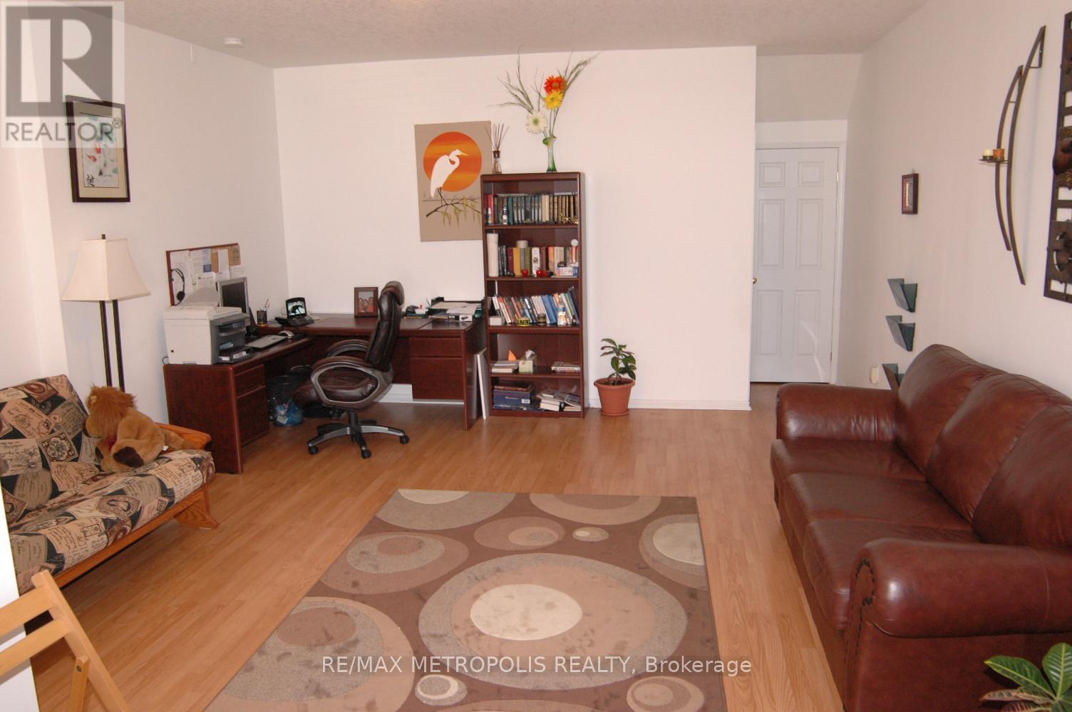 A living room with a brown leather couch and a brown rug.