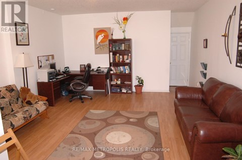 A living room with a brown leather couch and a brown rug.
