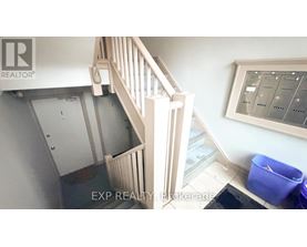A staircase with a railing and a wall-mounted thermostat.