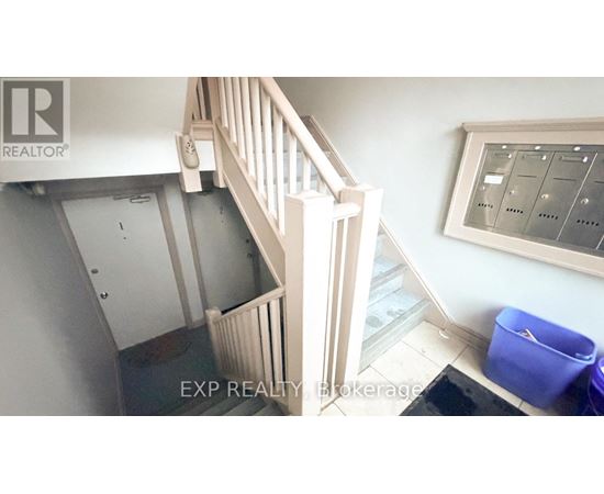 A staircase with a railing and a wall-mounted thermostat.