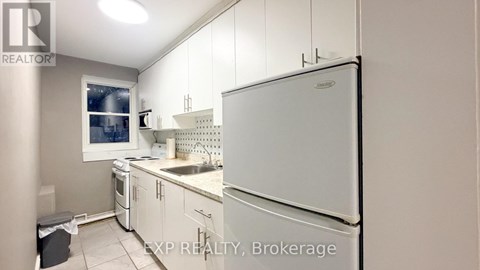 A kitchen with white appliances and cabinets.