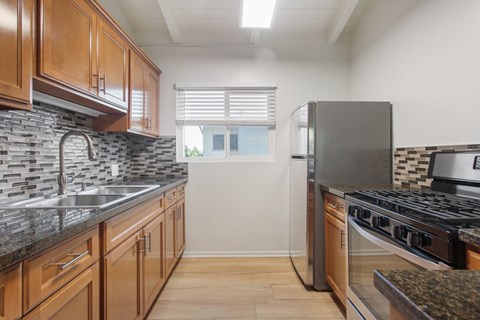 A kitchen with wooden cabinets and a black stove top oven.