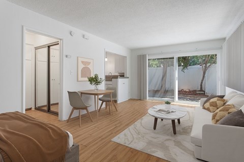 A modern living room with a dining area and sliding glass doors.