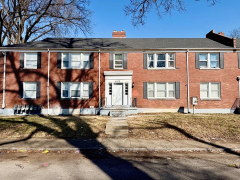 A red brick house with a white door and windows.