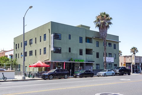 A street view of a building with cars parked in front.