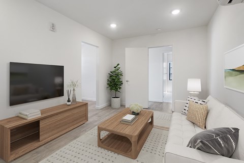 A modern living room with a white couch, a wooden coffee table, and a flat-screen TV.