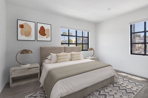 A bedroom with a large bed and two framed pictures on the wall.