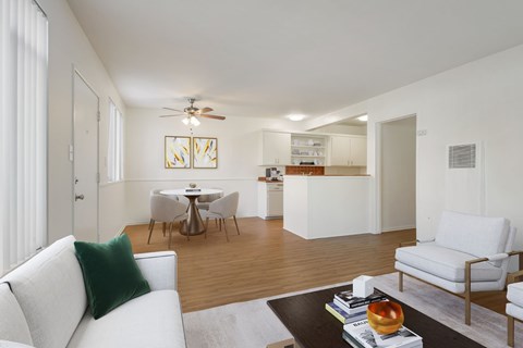 A living room with a white couch and a coffee table with books and an apple on it.