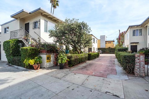 A residential street with houses on both sides and a sidewalk in the middle.