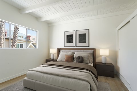 A bedroom with a large bed and two framed pictures on the wall.