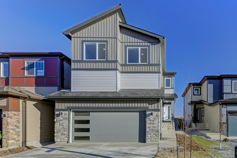 A modern house with a grey garage door and a grey roof.