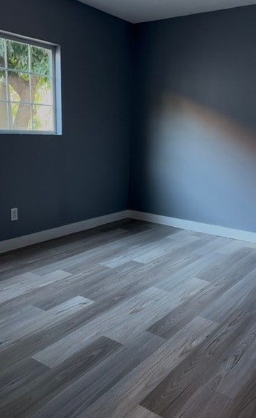 A room with a window and wooden flooring.