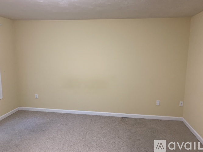A room with beige walls and carpeted floor.