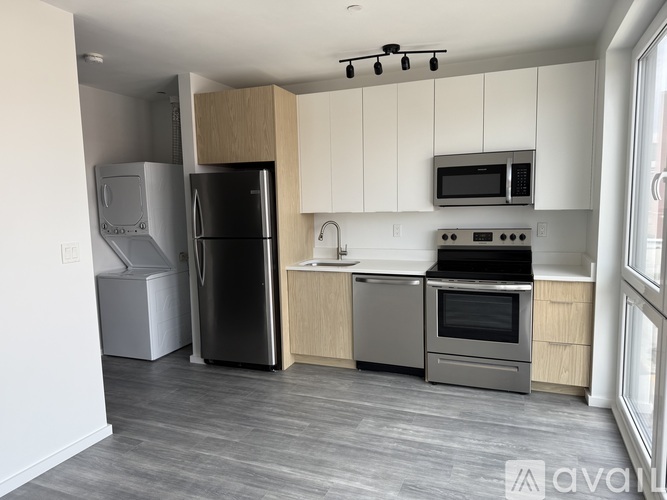 A kitchen with a refrigerator, oven, and microwave.