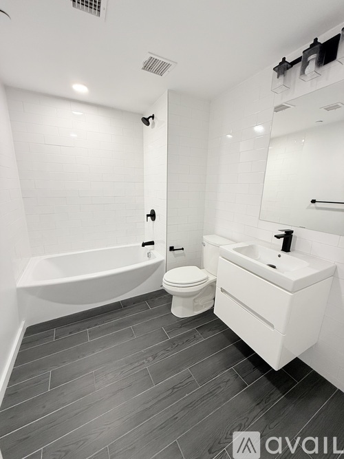 A bathroom with a white tub, sink, and toilet.