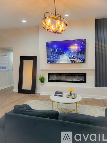 A living room with a grey sofa and a television mounted on the wall.