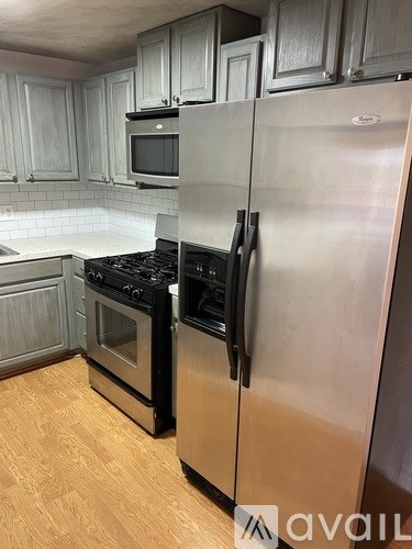 A kitchen with a stainless steel refrigerator and black stove.