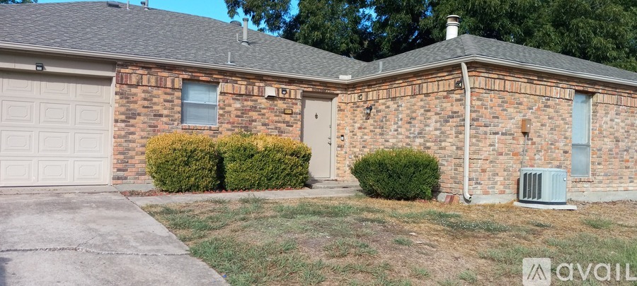 A brick house with a garage door and a window.