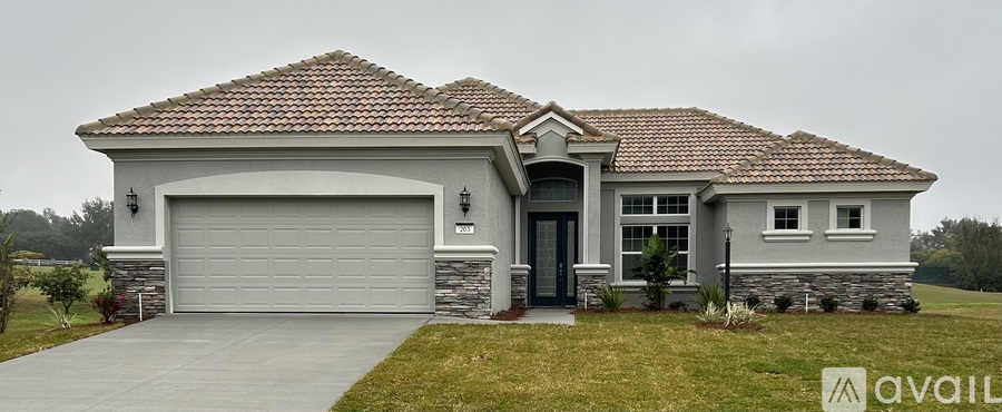 A house with a grey garage door and a brown roof.
