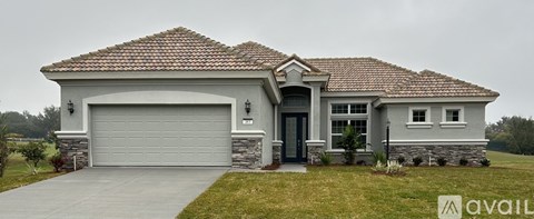 A house with a grey garage door and a brown roof.