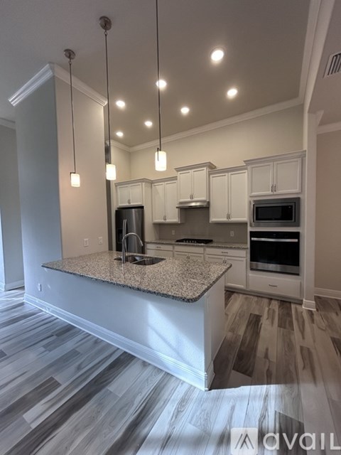 A kitchen with a granite countertop and a striped grey floor.
