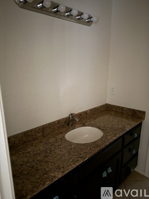 A bathroom with a sink and a vanity with drawers.