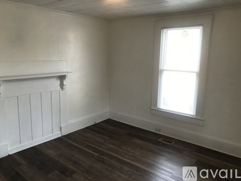 A room with a window and wooden flooring.
