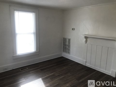 A room with a window and wooden flooring.