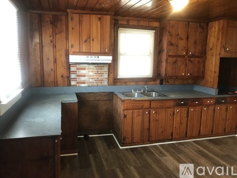 A kitchen with wooden cabinets and a brick backsplash is available.
