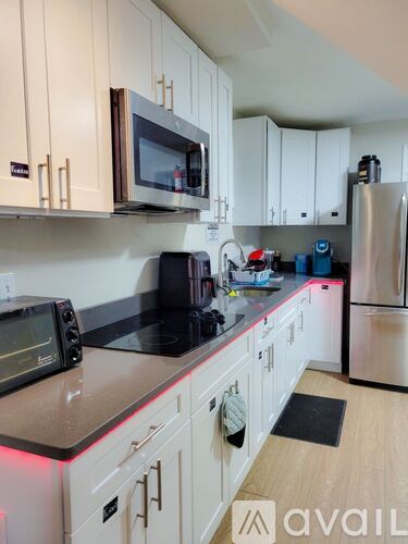 A kitchen with white cabinets and a black stove top.