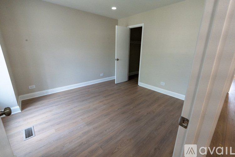 A room with wooden flooring and a white door.