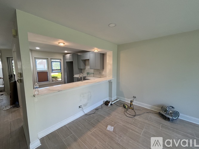 A room with a kitchen area and a window is available for rent.